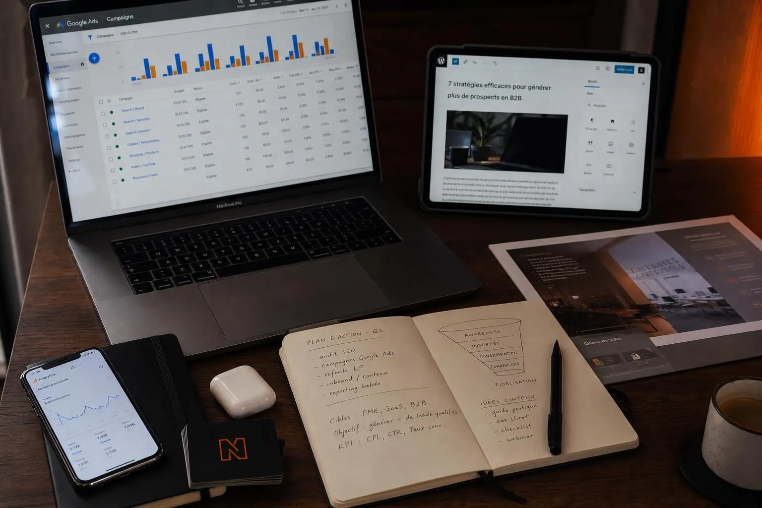 Espace de travail avec ordinateur, campagnes digitales et supports imprimés